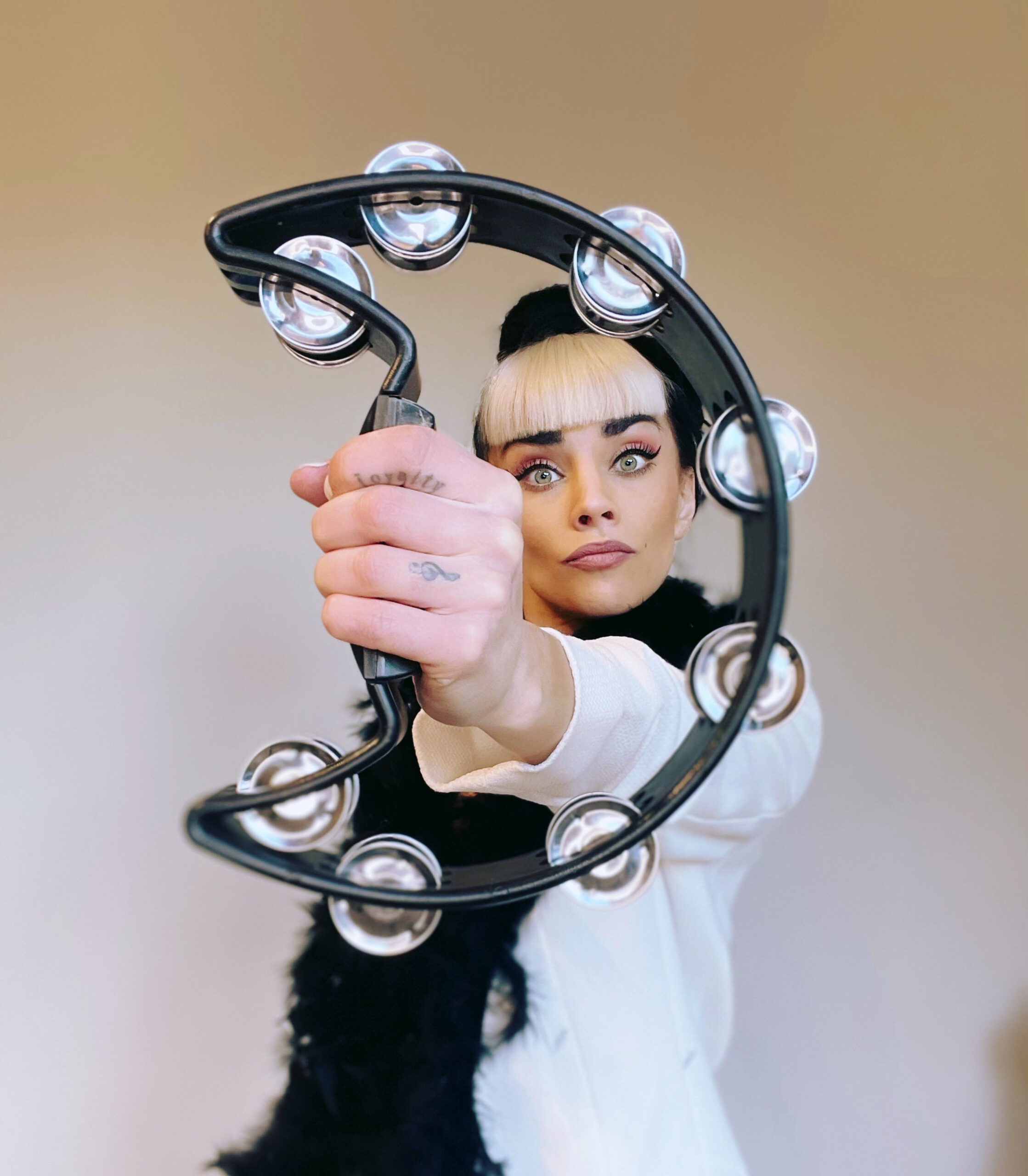 Jasmine Kara holding a tambourine